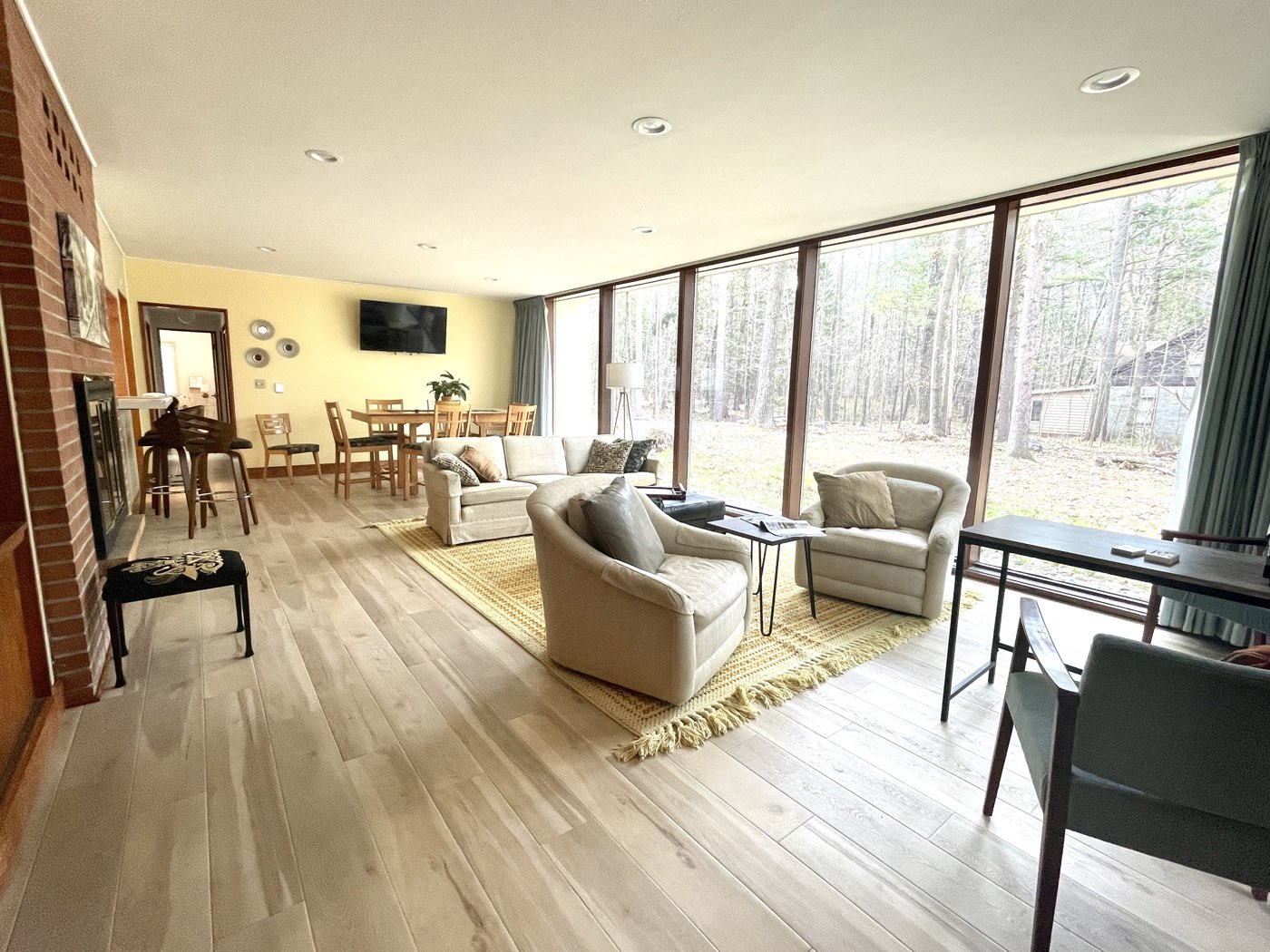 Living room with floor-to-ceiling windows and a brick fireplace